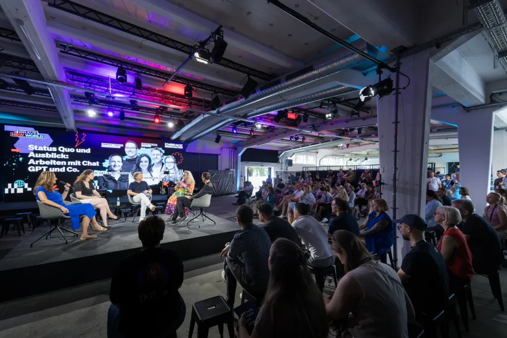 Weite Aufnahme einer Paneldiskussion beim EMBRACE Festival 2025 mit Publikum von hinten und von der Seite